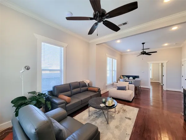 a living room with furniture and a wooden floor