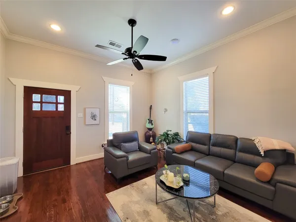 a living room with furniture a ceiling fan a window and a potted plant
