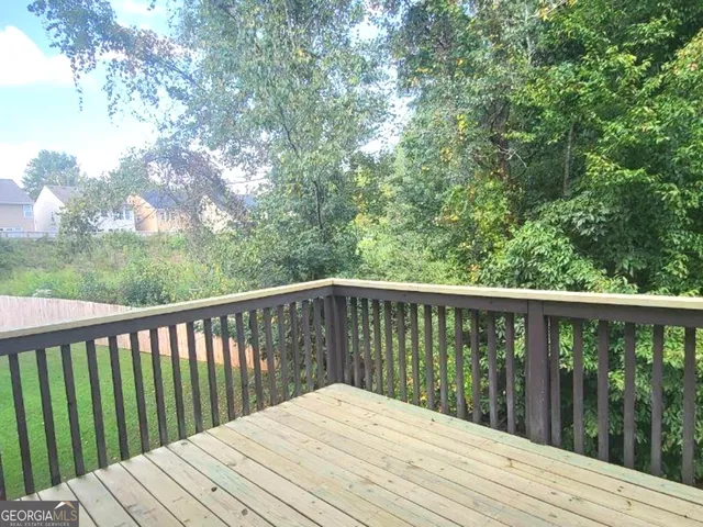 a balcony with wooden floor and wooden fence