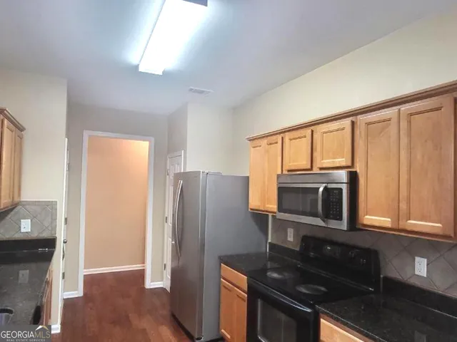 a view of hallway with window and wooden floor