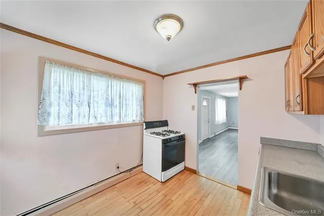 a kitchen with granite countertop a stove and a wooden floors