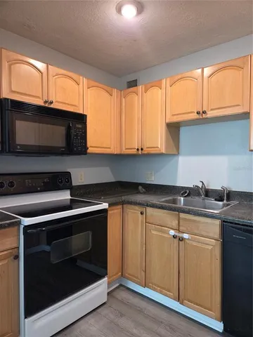 a kitchen with granite countertop cabinets stainless steel appliances and a window