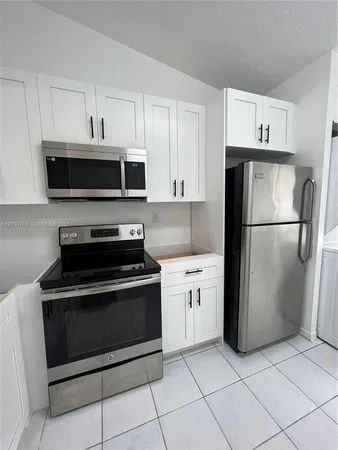 a kitchen with cabinets and steel stainless steel appliances