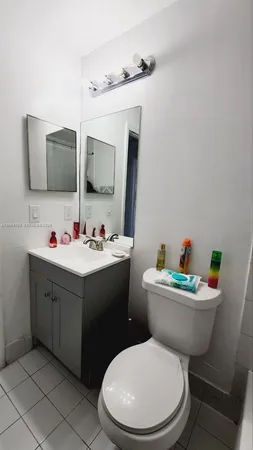 a bathroom with a sink mirror vanity and toilet
