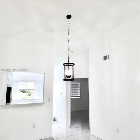 a view of a hallway with a dining table and chairs