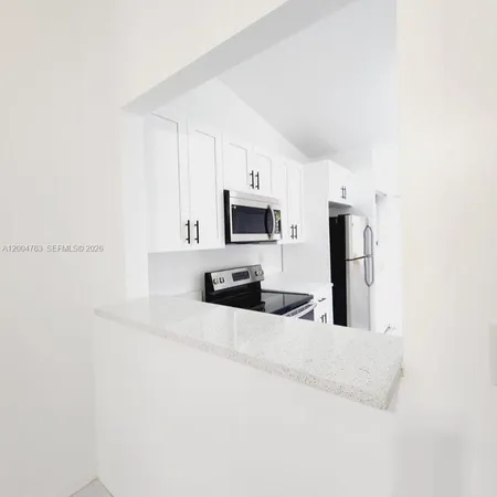 a kitchen with stainless steel appliances a microwave a sink and cabinets
