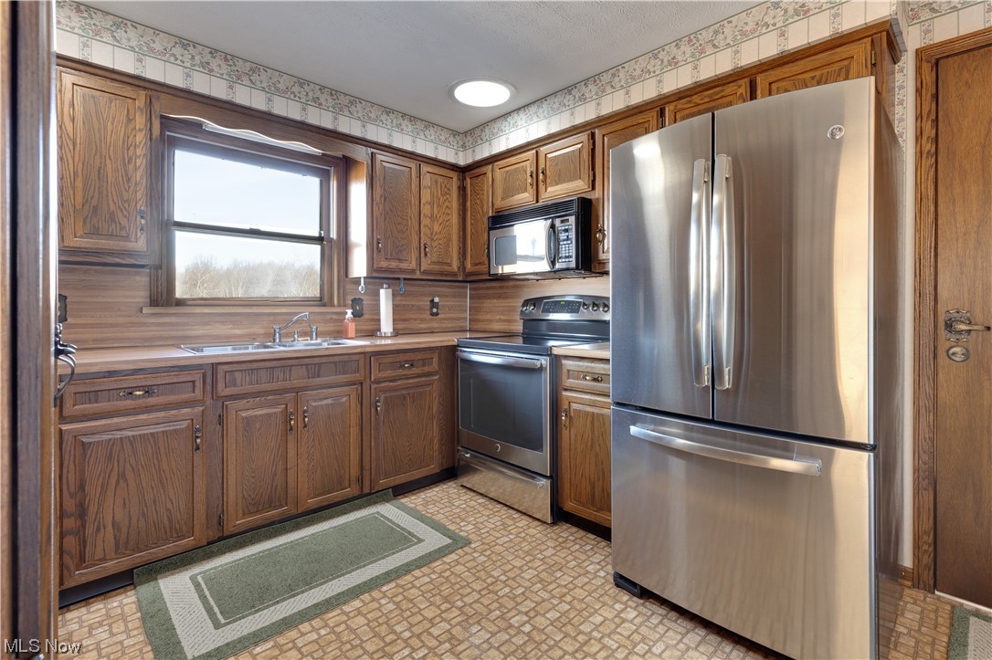 5419 Camp Road Ravenna, OH 44266 - Photo 18 of 32 Kitchen featuring sink, appliances with stainless steel finishes, and light tile floors