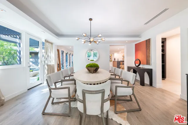 a living room with furniture a dining table and a large window