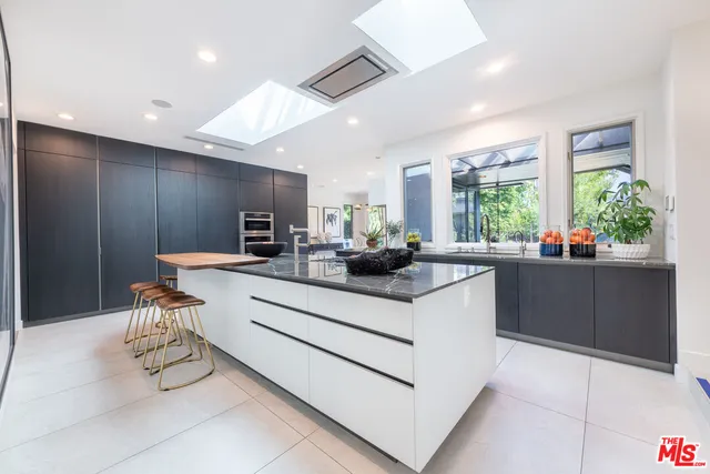 a kitchen with stainless steel appliances kitchen island granite countertop a sink and cabinets