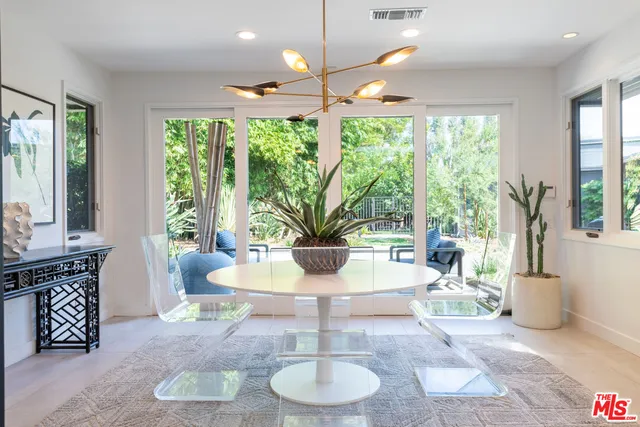 a living room with patio furniture and a potted plant