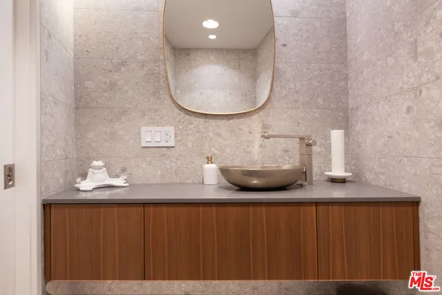 a bathroom with a granite countertop sink and a mirror