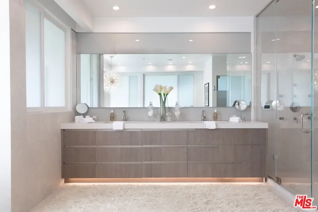 a bathroom with a sink mirror and a shower