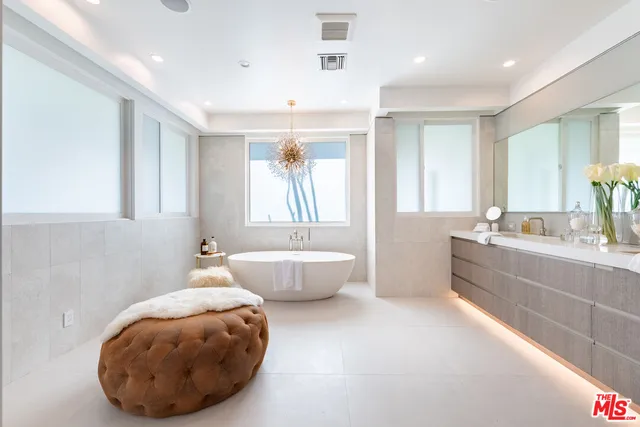 a spacious bathroom with a large tub sink and mirror