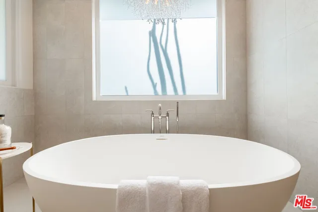 a white tub sitting in a bathroom next to a window