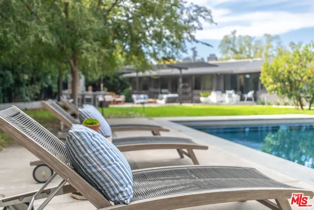 a view of a house with pool and chairs