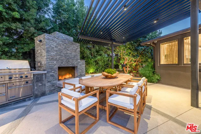 a patio with a table and chairs and potted plants