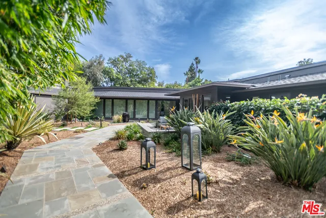 a view of a house with backyard and sitting area