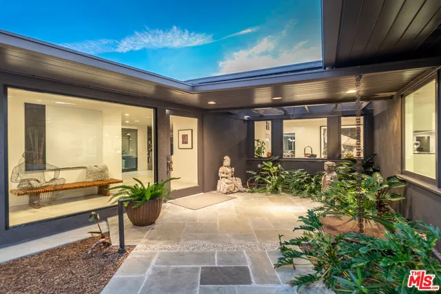 a lobby with furniture and potted plants