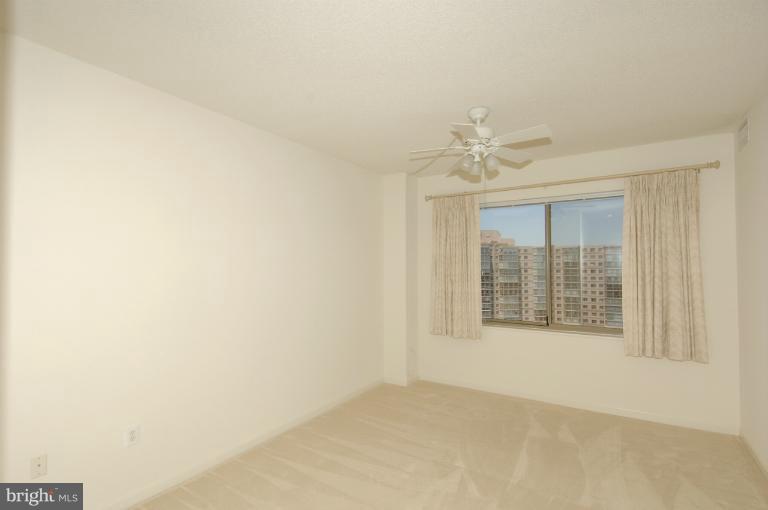 19375 Cypress Ridge Terrace, Unit 1007 Leesburg, VA 20176 - Photo 7 of 19 an empty room with a ceiling fan and windows