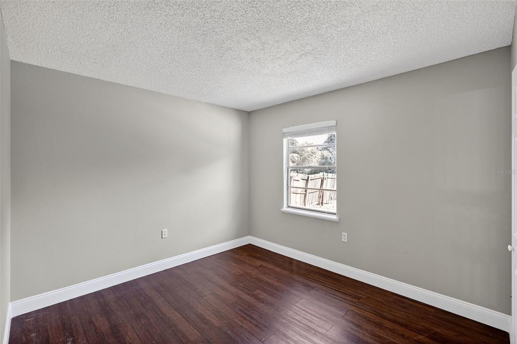 2737 East Dorchester Drive Deltona, FL 32738 - Photo 14 of 32 an empty room with wooden floor and windows