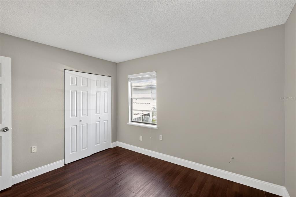 2737 East Dorchester Drive Deltona, FL 32738 - Photo 23 of 32 an empty room with wooden floor and windows