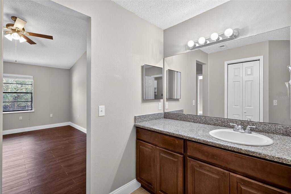 2737 East Dorchester Drive Deltona, FL 32738 - Photo 27 of 32 a bathroom with double vanity sinks a vanity a lamp and a mirror