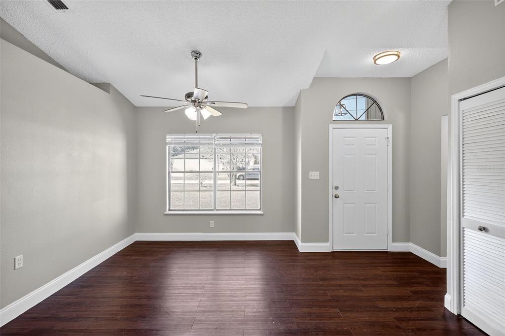 2737 East Dorchester Drive Deltona, FL 32738 - Photo 7 of 32 an empty room with wooden floor mirror and windows
