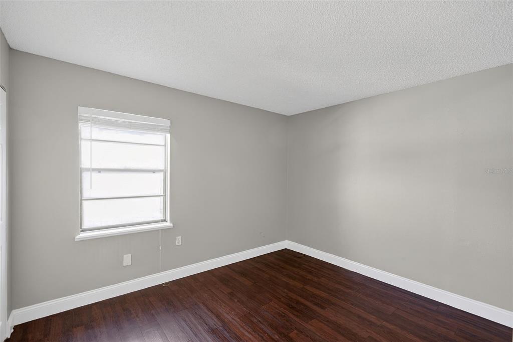 2737 East Dorchester Drive Deltona, FL 32738 - Photo 8 of 32 a view of an empty room with wooden floor and a window