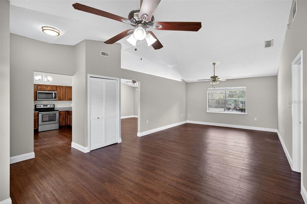 2737 East Dorchester Drive Deltona, FL 32738 - Photo 10 of 32 a view of an empty room with wooden floor and a ceiling fan