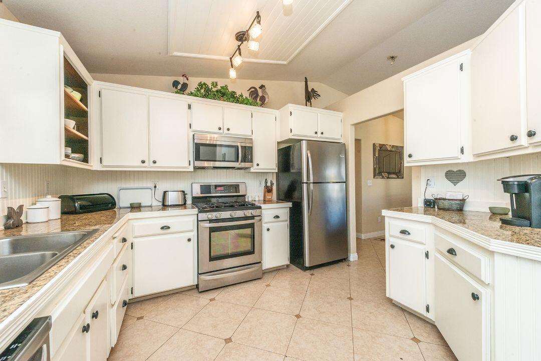 2771 North Street Anderson, CA 96007 - Photo 22 of 55 a kitchen with stainless steel appliances granite countertop a refrigerator sink and white cabinets
