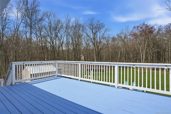 a balcony with wooden floor and trees in the background