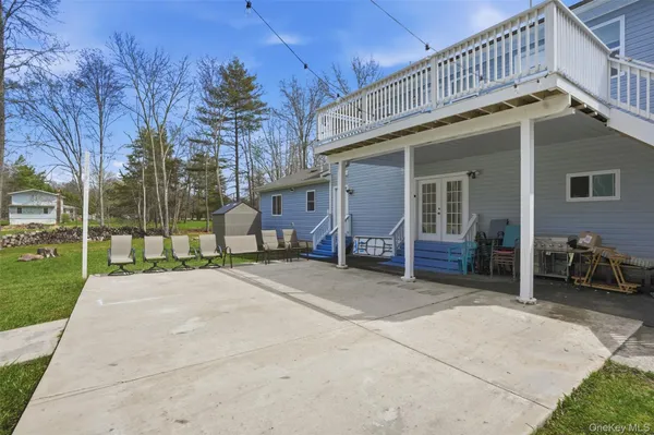 a view of a house with a patio and a yard