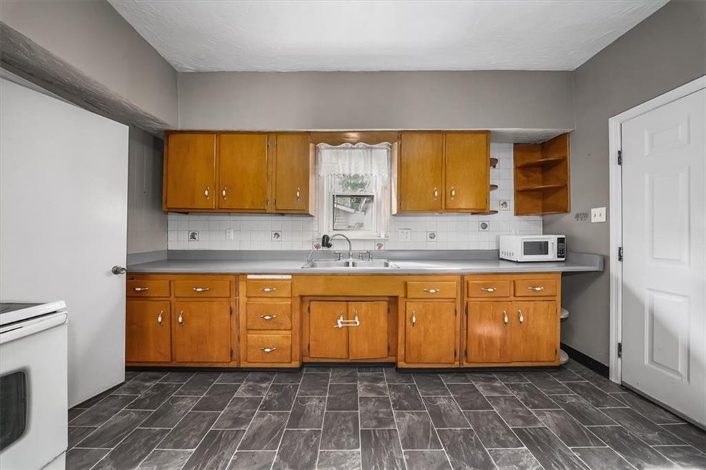 216 6th Street Monaca, PA 15061 - Photo 10 of 31 a bathroom with a granite countertop sink a mirror and a bathtub