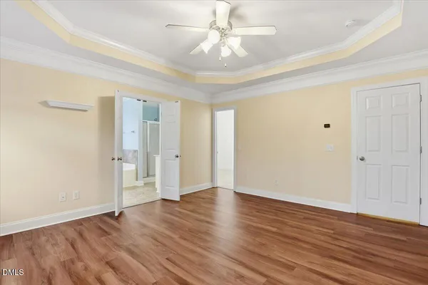 a view of an empty room with wooden floor fireplace and a window