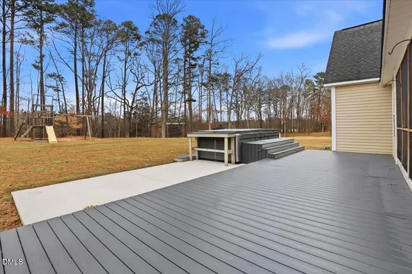 a view of a swimming pool with a yard and wooden fence