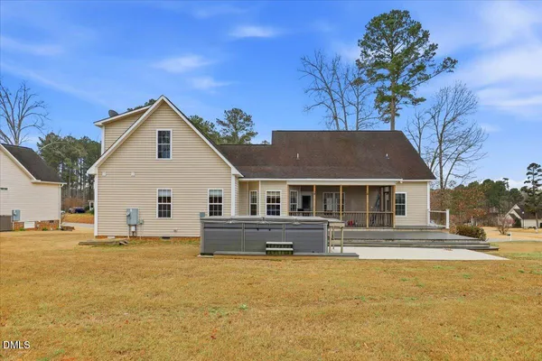 a front view of house with yard and trees in the background