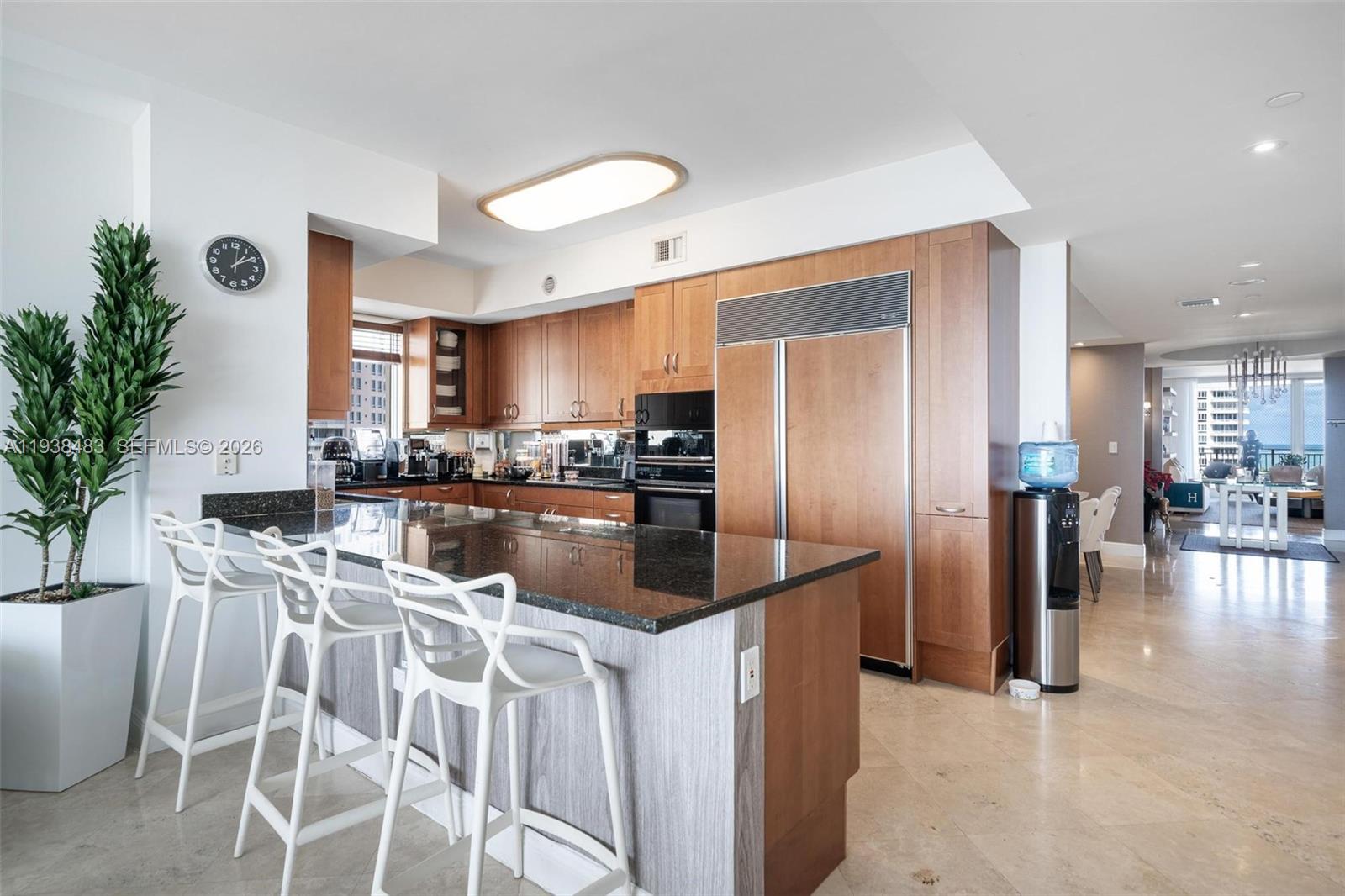 799 Crandon Boulevard, Unit 908 Key Biscayne, FL 33149 - Photo 11 of 30 a kitchen with stainless steel appliances granite countertop a refrigerator a stove a sink a dining table and chairs with wooden floor