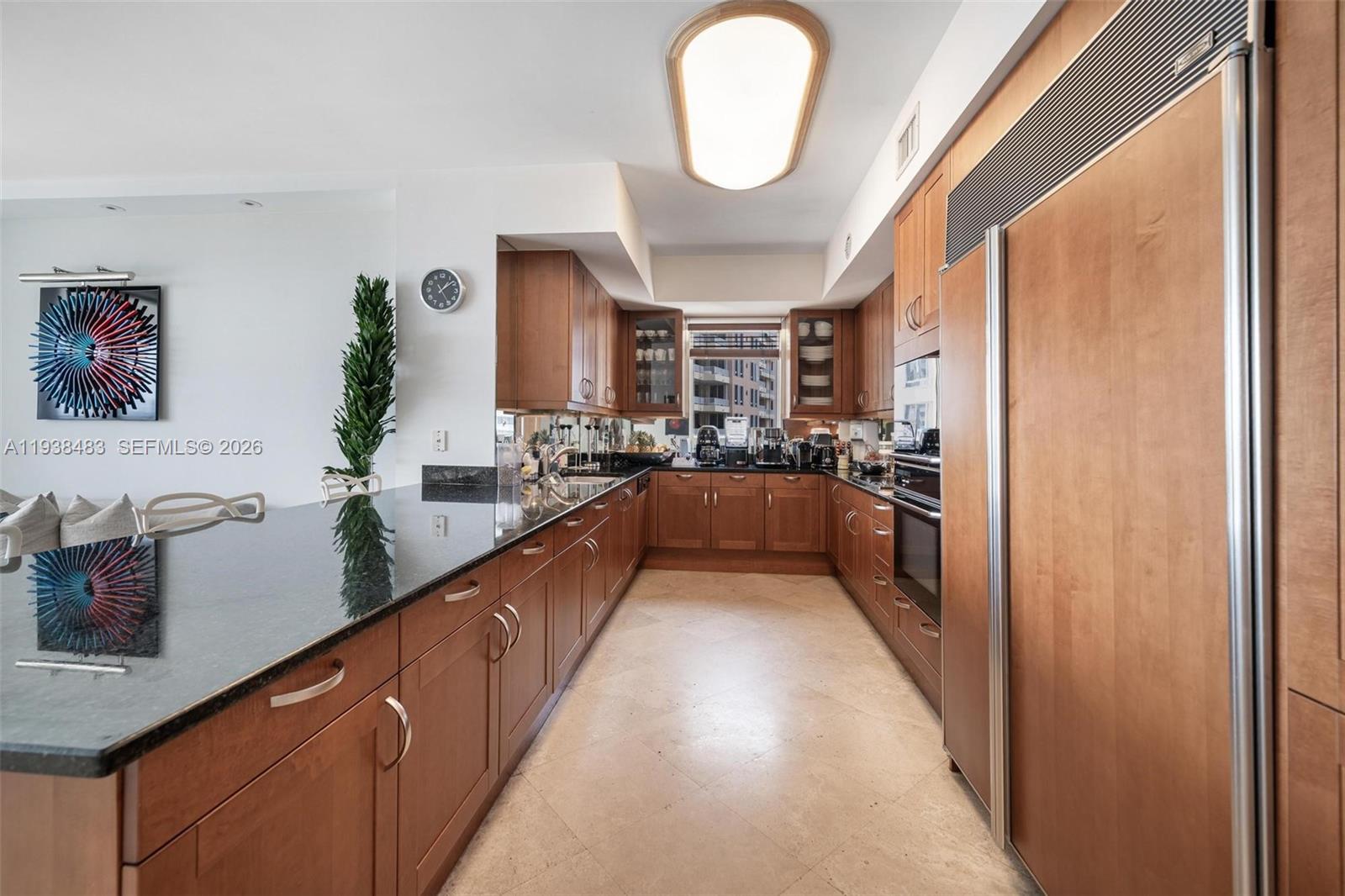 799 Crandon Boulevard, Unit 908 Key Biscayne, FL 33149 - Photo 12 of 30 a large kitchen with stainless steel appliances granite countertop a lot of counter space and a refrigerator