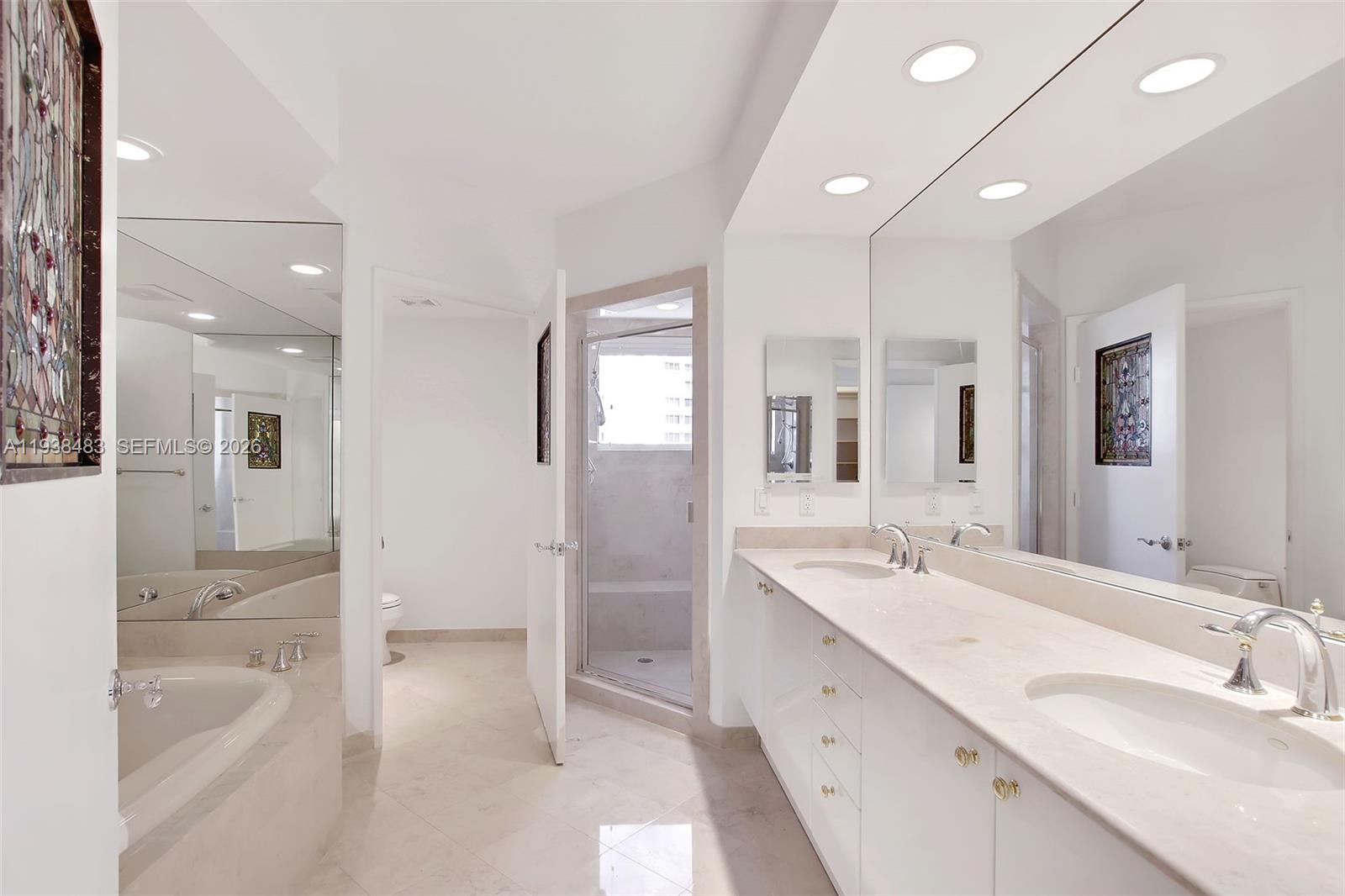 799 Crandon Boulevard, Unit 908 Key Biscayne, FL 33149 - Photo 19 of 30 a spacious bathroom with a granite countertop sink mirror and shower