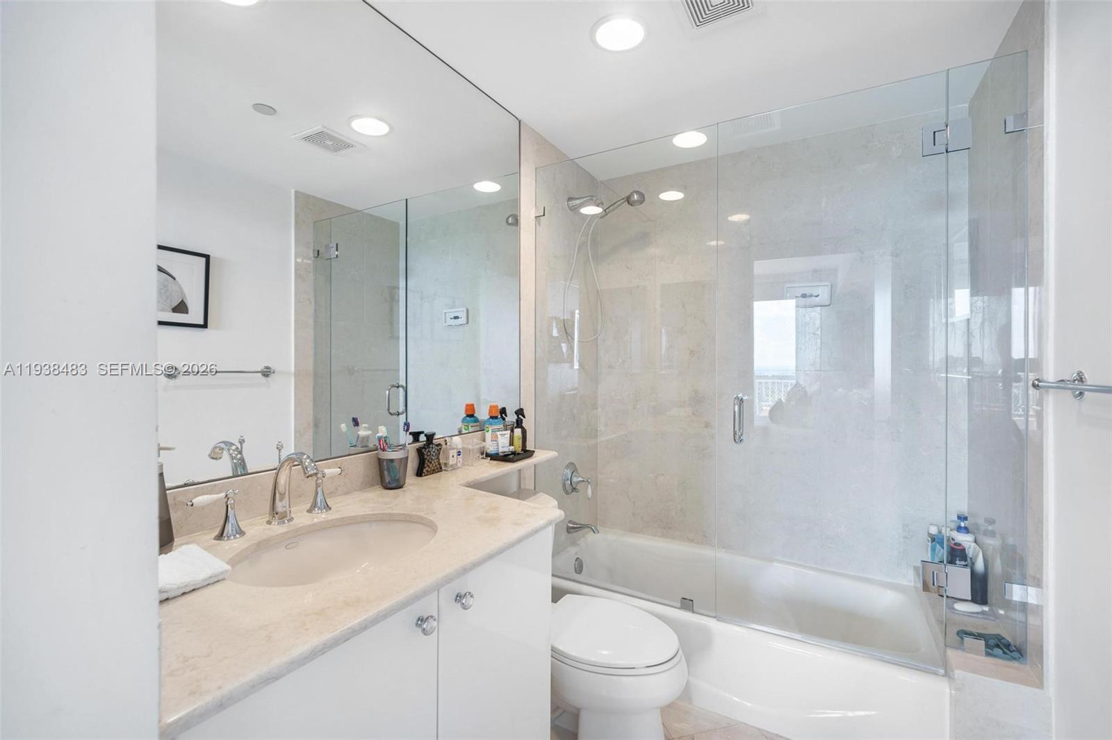 799 Crandon Boulevard, Unit 908 Key Biscayne, FL 33149 - Photo 24 of 30 a bathroom with a bathtub shower sink vanity mirror and toilet