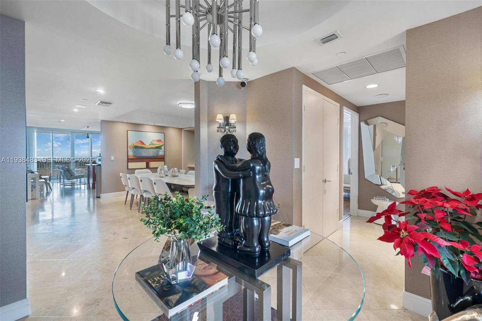 799 Crandon Boulevard, Unit 908 Key Biscayne, FL 33149 - Photo 7 of 30 a dining room with furniture and a chandelier