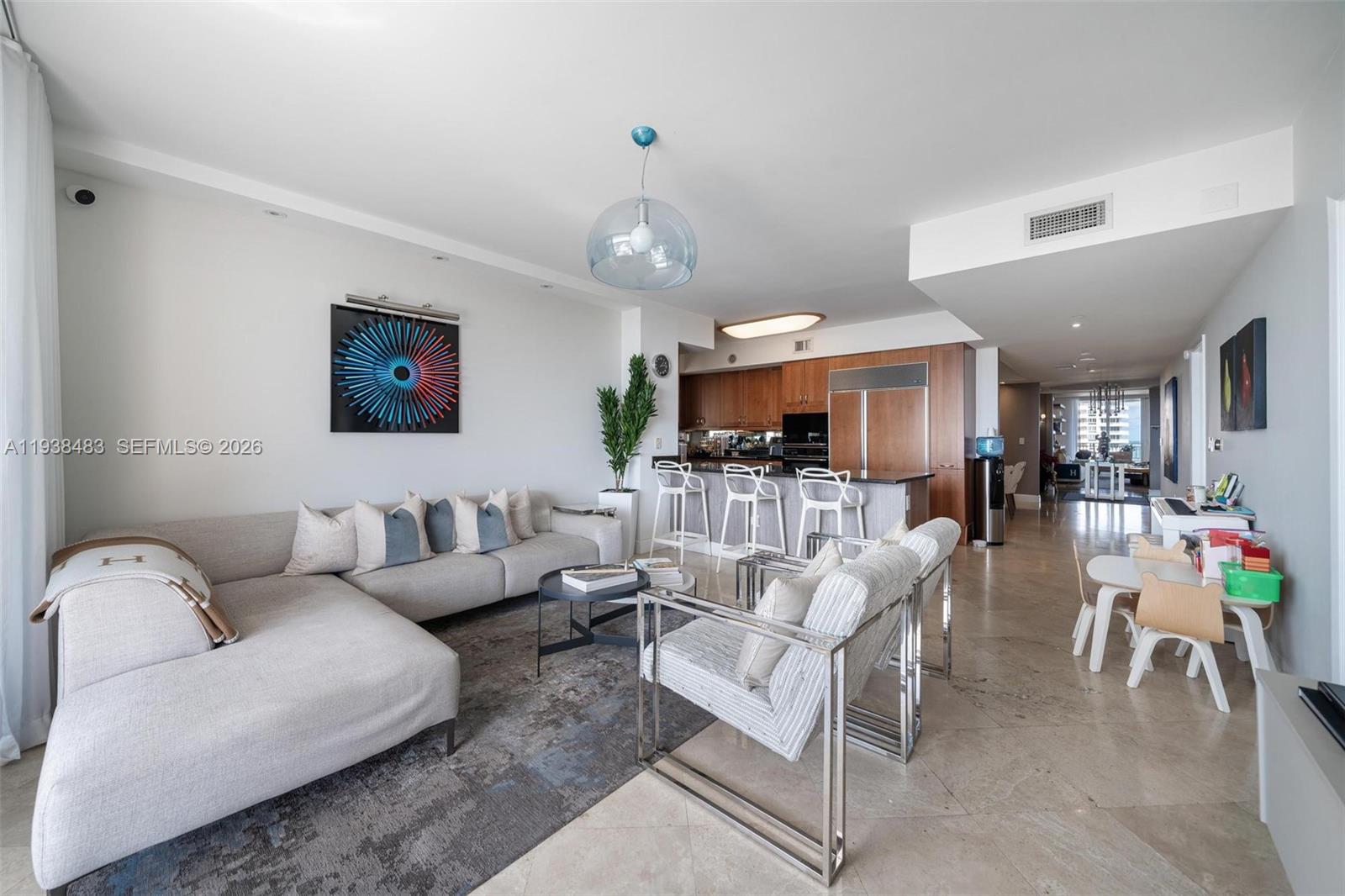 799 Crandon Boulevard, Unit 908 Key Biscayne, FL 33149 - Photo 9 of 30 a living room with furniture kitchen view and a chandelier