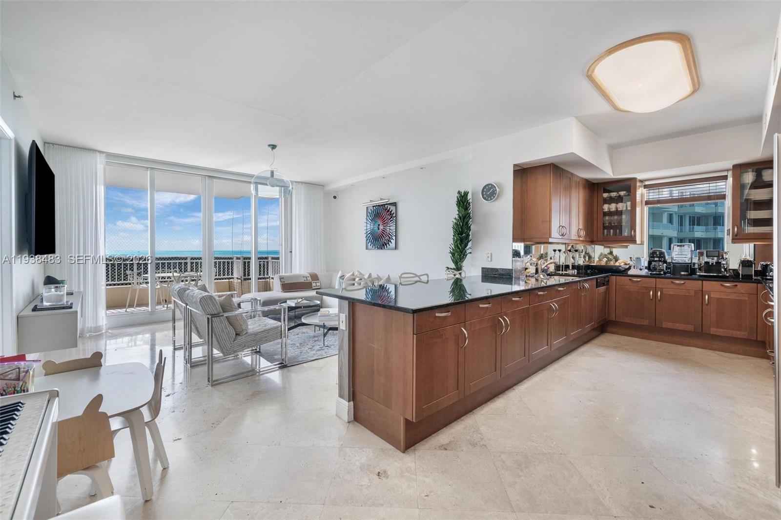 799 Crandon Boulevard, Unit 908 Key Biscayne, FL 33149 - Photo 10 of 30 a living room with stainless steel appliances kitchen island granite countertop a couch and cabinets