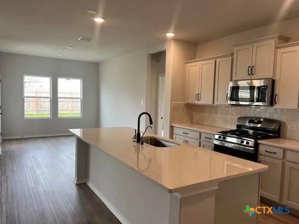 a view of kitchen with wooden floor and electronic appliances