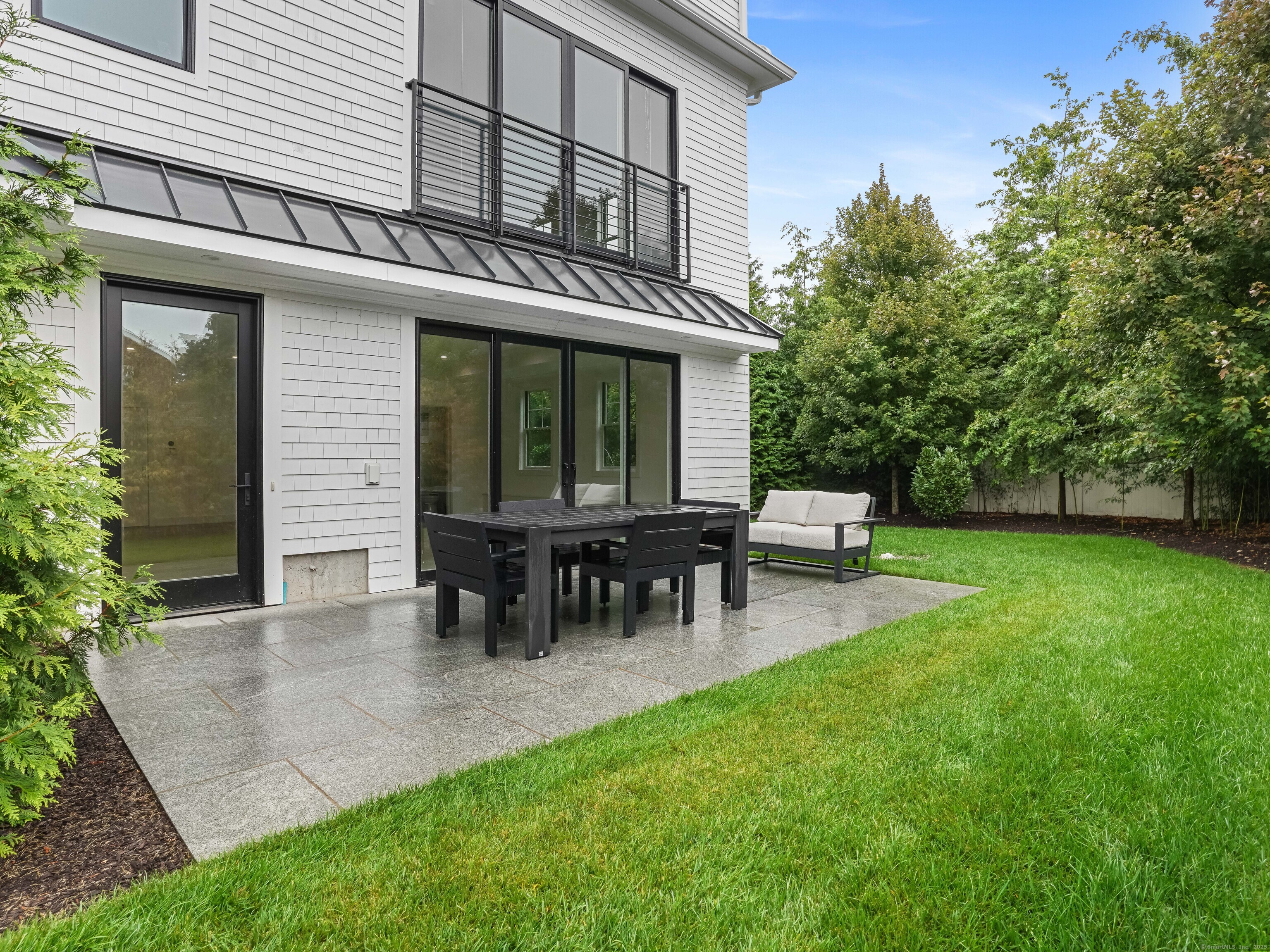 a view of a house with a back yard and sitting area