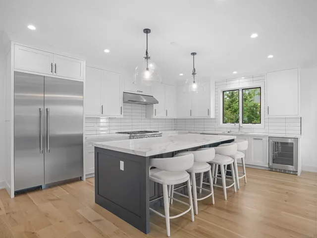 a kitchen with kitchen island a large counter top space appliances and cabinets