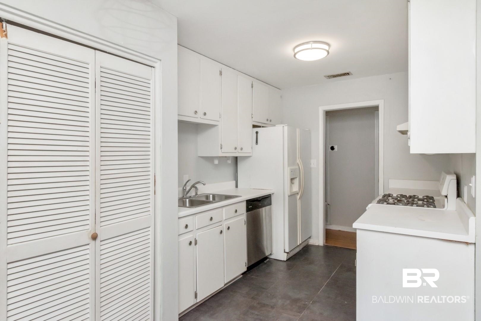 320 Vanderbilt Drive Mobile, AL 36608 - Photo 22 of 39 Kitchen with stainless steel dishwasher, white range with gas cooktop, sink, and white cabinets