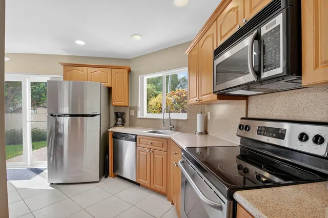 a kitchen with stainless steel appliances granite countertop a refrigerator sink and stove
