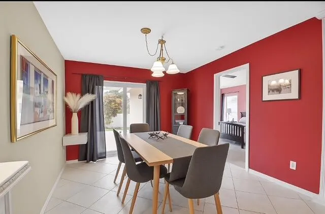 a dining room with furniture a chandelier and window