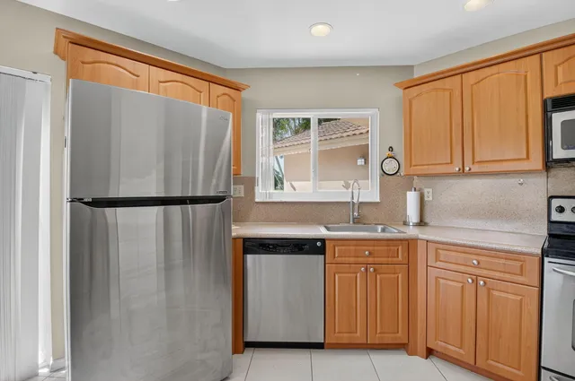 a kitchen with stainless steel appliances granite countertop a refrigerator and a sink